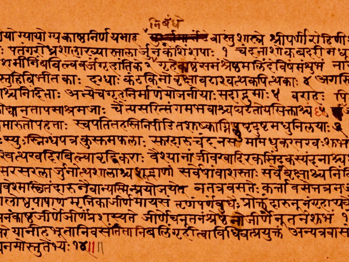 A folio of a Sanskrit manuscript handwritten in Devanagari script on ochre paper